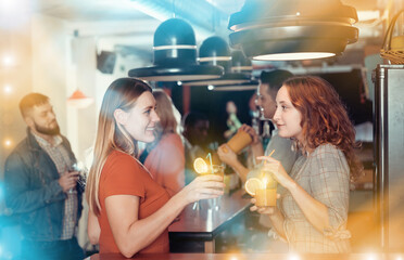 Young women drinking cocktails and talking on  party