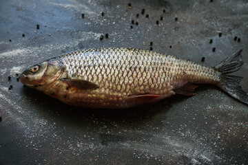 River crucian prepared for frying on a wooden table.