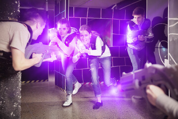 Women having fun on dark lasertag arena