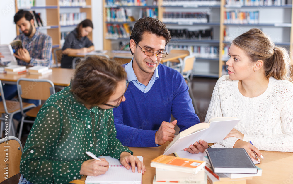 Canvas Prints Teacher working with female students in library