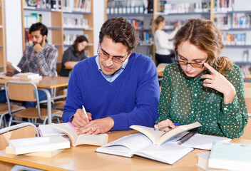 Couple of students studying in library