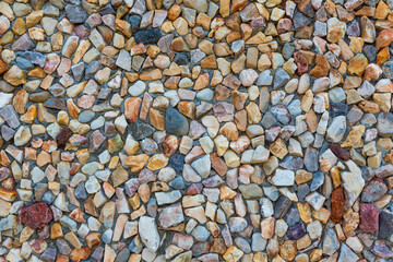 colored unprocessed rocky stones of natural origin, a wall of stones in concrete, background for walls and wallpapers