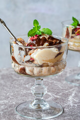 Ice cream dessert with poached pears and chocolate sauce garnished with fresh mint