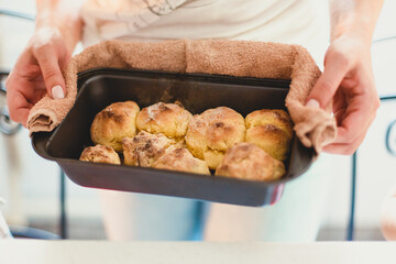 
hands hold a cookie sheet with cookies