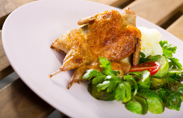 Tasty fried quail tobacco served  with boiled and fresh vegetables