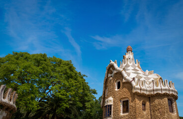 Naklejka premium Stone house with mosaic roof in the famous Park Guell (Parc Guell 1900-1914), designed by Antoni Gaudi (1852-1926). UNESCO World Heritage Site in Barcelona, Catalonia, Spain, Europe