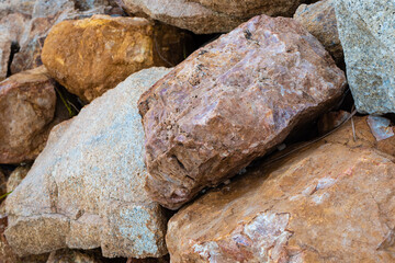 colored rocky stones of natural origin, background for walls and wallpapers, highlighted texture of the material, natural color blocks