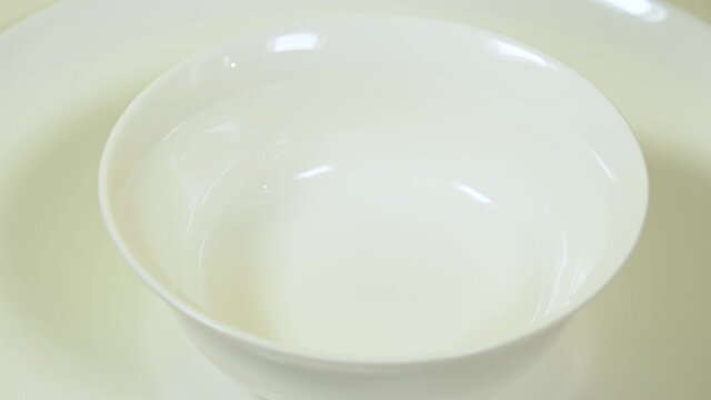 Closeup view 4k video footage of empty white plate standing on table.