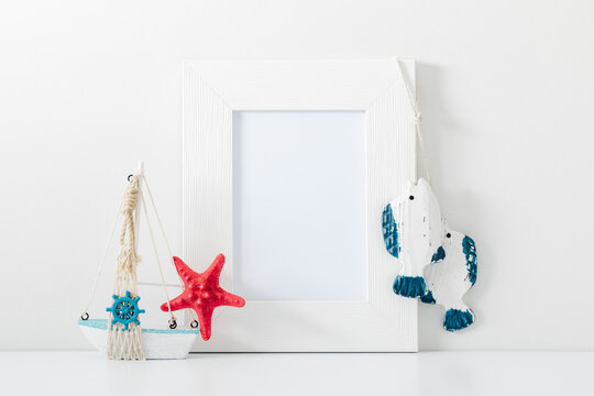 White frame mockup in interior with sea elements on white wall background. Template frame for text. Poster mockup.