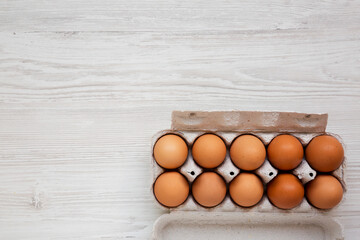 Raw Brown Eggs in a paper box, top view. Flat lay, overhead, from above. Copy space.