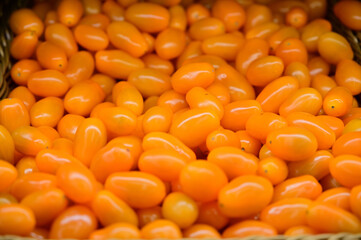 Photo of orange cherry tomatoes ready for sale.