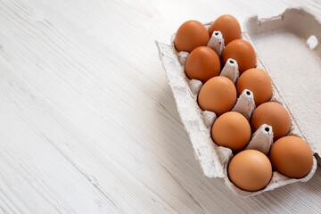 Raw Brown Eggs in a paper box, side view. Copy space.