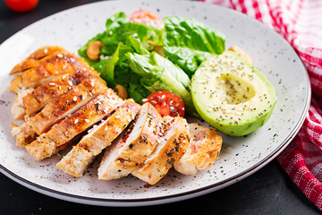 Trendy salad. Chicken grilled fillet with salad fresh tomatoes and avocado. Healthy food, ketogenic diet, diet lunch concept. Keto/Paleo diet menu.