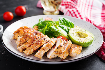 Trendy salad. Chicken grilled fillet with salad fresh tomatoes and avocado. Healthy food, ketogenic diet, diet lunch concept. Keto/Paleo diet menu.