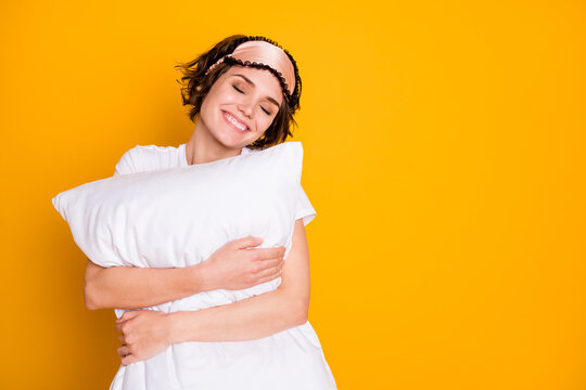 Close-up portrait of her she nice attractive lovely pretty cute glad dreamy cheery brown-haired girl holding in hands cosy pillow isolated on bright vivid shine vibrant yellow color background