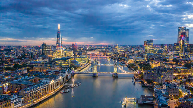 Aerial drone photograph of Tower Bridge and the River Thames at dusk with City Hall and The Shard in the background. London England. 