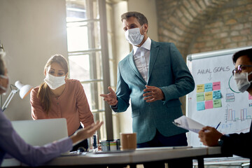 Businessman wearing protective face mask while talking on a meeting in the office.