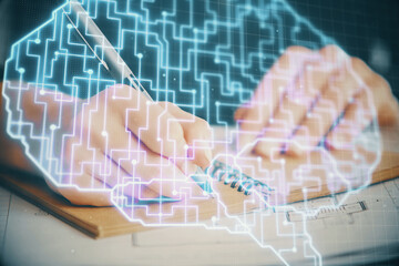 Multi exposure of writing hand on background with brain hologram. Concept of learning.