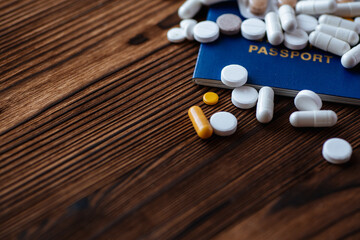 Fototapeta na wymiar A pills, passport on a wooden background. COVID-19 and travel concept. Copy space