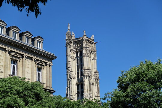 Tour Saint Jaques et immeuble parisien. Ciel bleu et arbre.