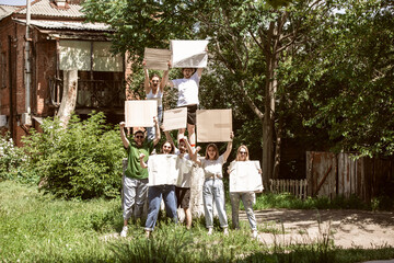 Diverse group of people protesting with blank sign. Protest against human rights, abuse of freedom, social issues, actual problems. Men and women on the street look angry, screaming. Copyspace.