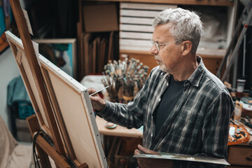 Senior artist painting in his studio