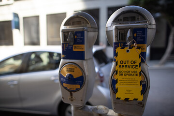 Safety workplaces yellow out of service tag attached on faulty damage of defect car parking metre...