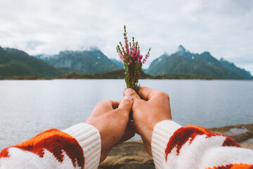 Hand holding flowers foggy mountains landscape Travel lifestyle vacations outdoor man walking alone...