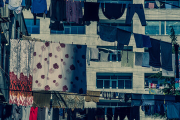 Laundry is hanging on the clothesline. Ropes are pulled between houses in the city. The clothes are air dried. Sunny. Day. Georgia.