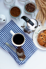 Still life with a coffee maker and cookies. Breakfast top view. Coffee grains poured from a can on kitchen table. Coffee cup mood. Coffee bean, Food background.