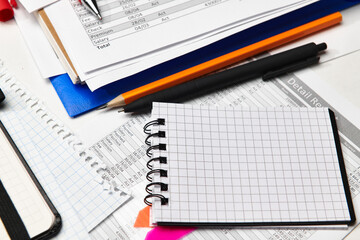 Top view of office employee's desk - work with financial reports, analysis and accounting, tables and graphs, various office items for bookkeeping