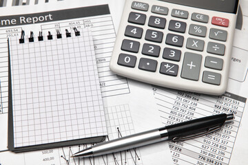 Top view of office employee's desk - work with financial reports, analysis and accounting, tables and graphs, various office items for bookkeeping