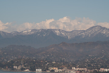 View of the foothills of the Caucasus. High peaks are covered with snow. Mountains against the blue sky. Day. Sunny. Georgia.