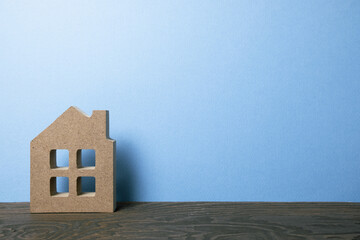 House model on wooden table with blue background. Real estate concept