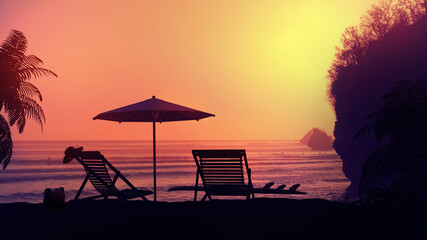 Tropical resort beach under the setting sun's rays.