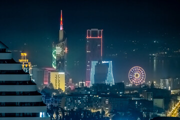 Panorama of the night city of Batumi, Georgia. View from the skyscraper. The shining of multi-colored lights and lights of buildings.