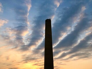 Tall chimney smokestack at sunrise