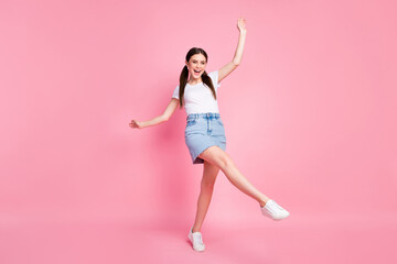 Fototapeta na wymiar Full length photo of pretty lady enjoy sunny day weather dancing students party excited wear casual white t-shirt mini denim skirt shoes isolated pastel pink color background