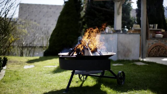 Fire burning on a fire pit in the garden on a sunny day