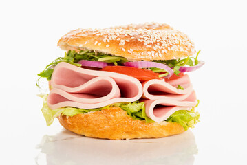fresh delicious bagel with sausage slices on white background
