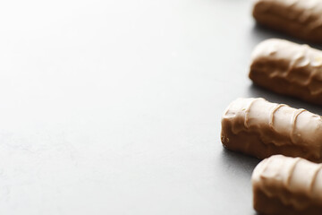 Chocolate bars on a black background in backlight. Chocolate with filling. Sweet sweets for snack and tea.