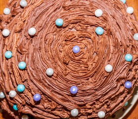 Creamy chocolate frosting with colorful candy ball decorations