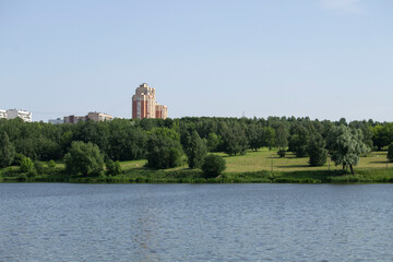 Multistorey building in the park on the bank of the river