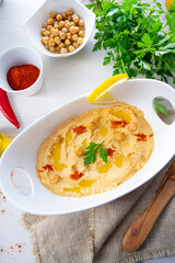 hummus paste with lemon and chilli on white background