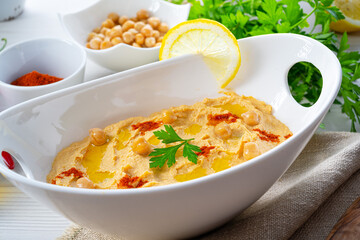 hummus paste with lemon and chilli on white background