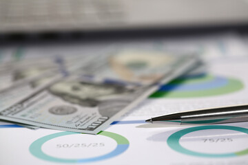 Close up of dollar banknotes and ball pen on office desk with documents