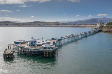Fototapeta na wymiar Llandudno Town and Pier North wales, the beach and sea. with Snowdonia mountains in the background. Aerial photograph