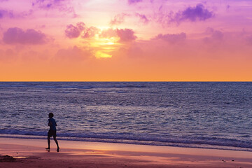 silhouette jogging on the beach with sunset sweet twilight sky colour in Phuket Thailand