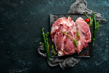 Piece of fresh raw pork from the neck, with ingredients and spices on a kitchen background. Meat....