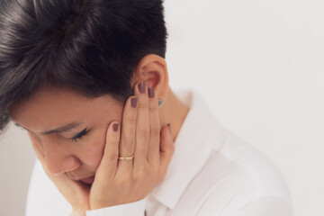 Closeup portrait of beautiful & stylish middle aged Asian married woman put her hands on face with wedding ring, close her eyes with sad emotion. Marriage problems, Divorce and Depression concept